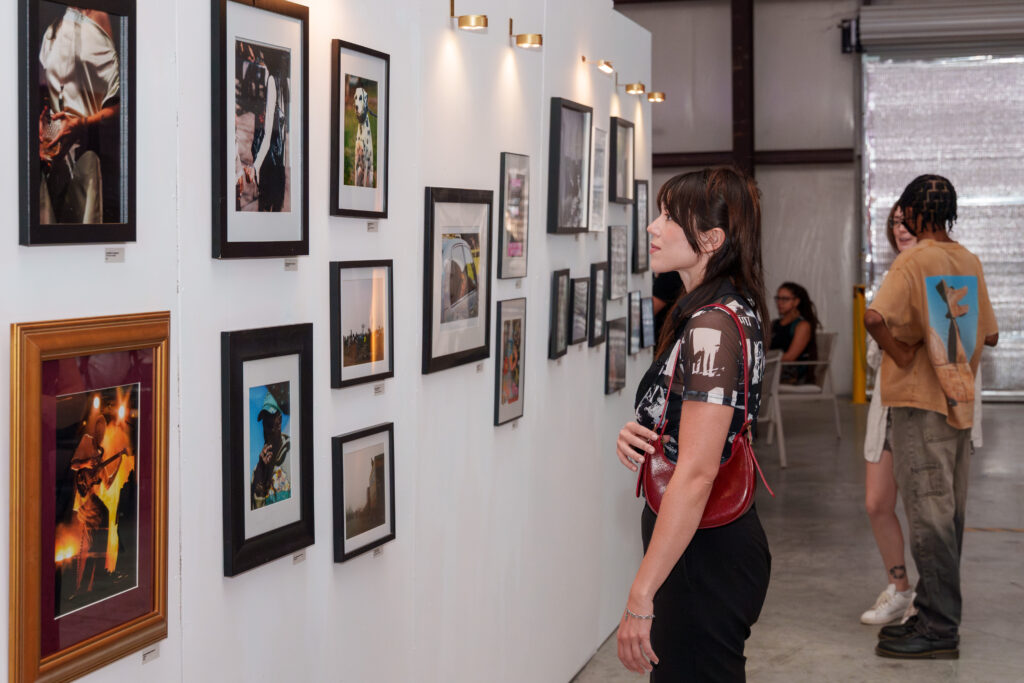 girl looking at photos on the wall at the2025 earworm expo